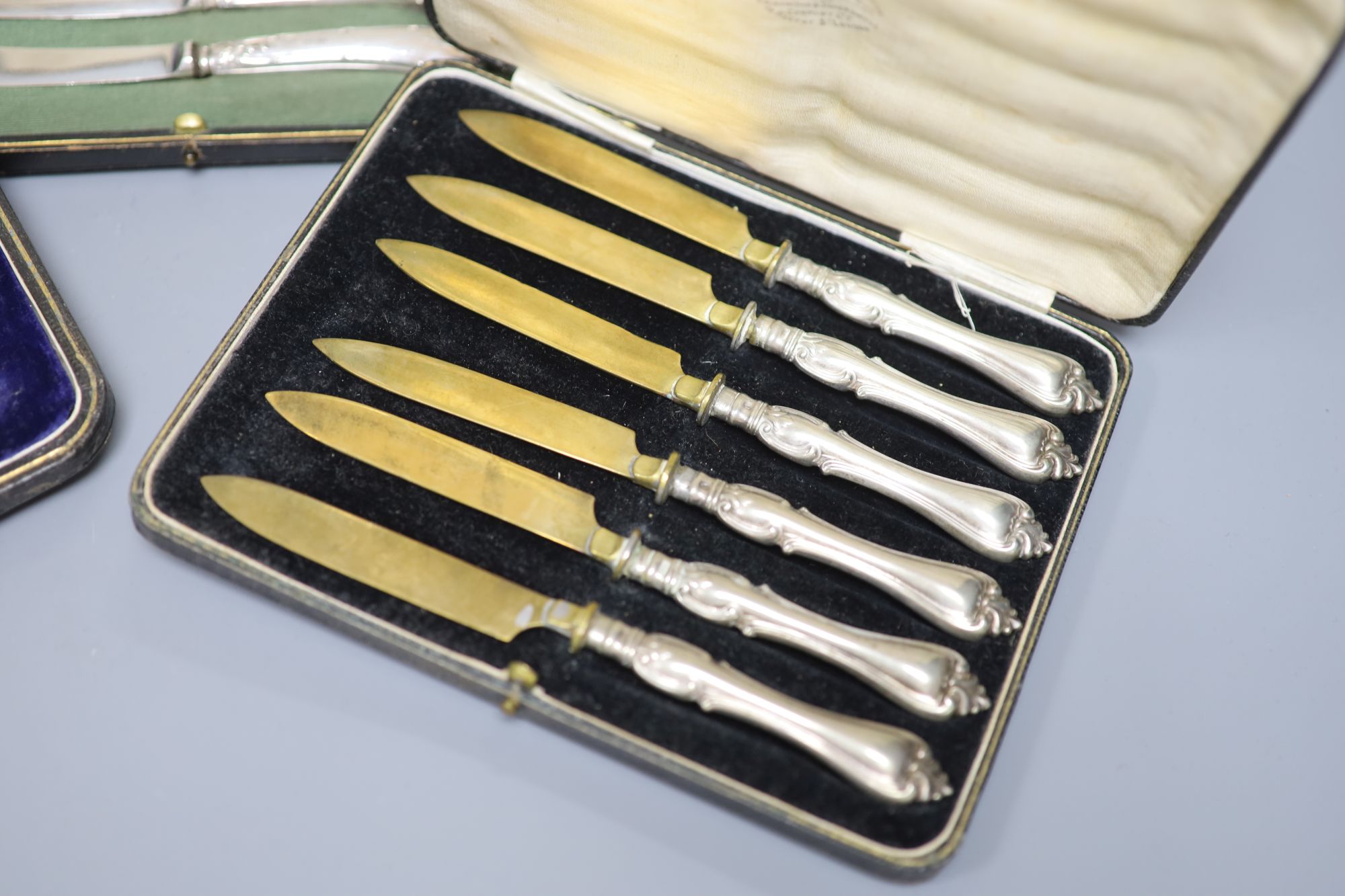 A cased set of six silver pistol handles tea knives(a.f.) and two other cased sets of knives.
